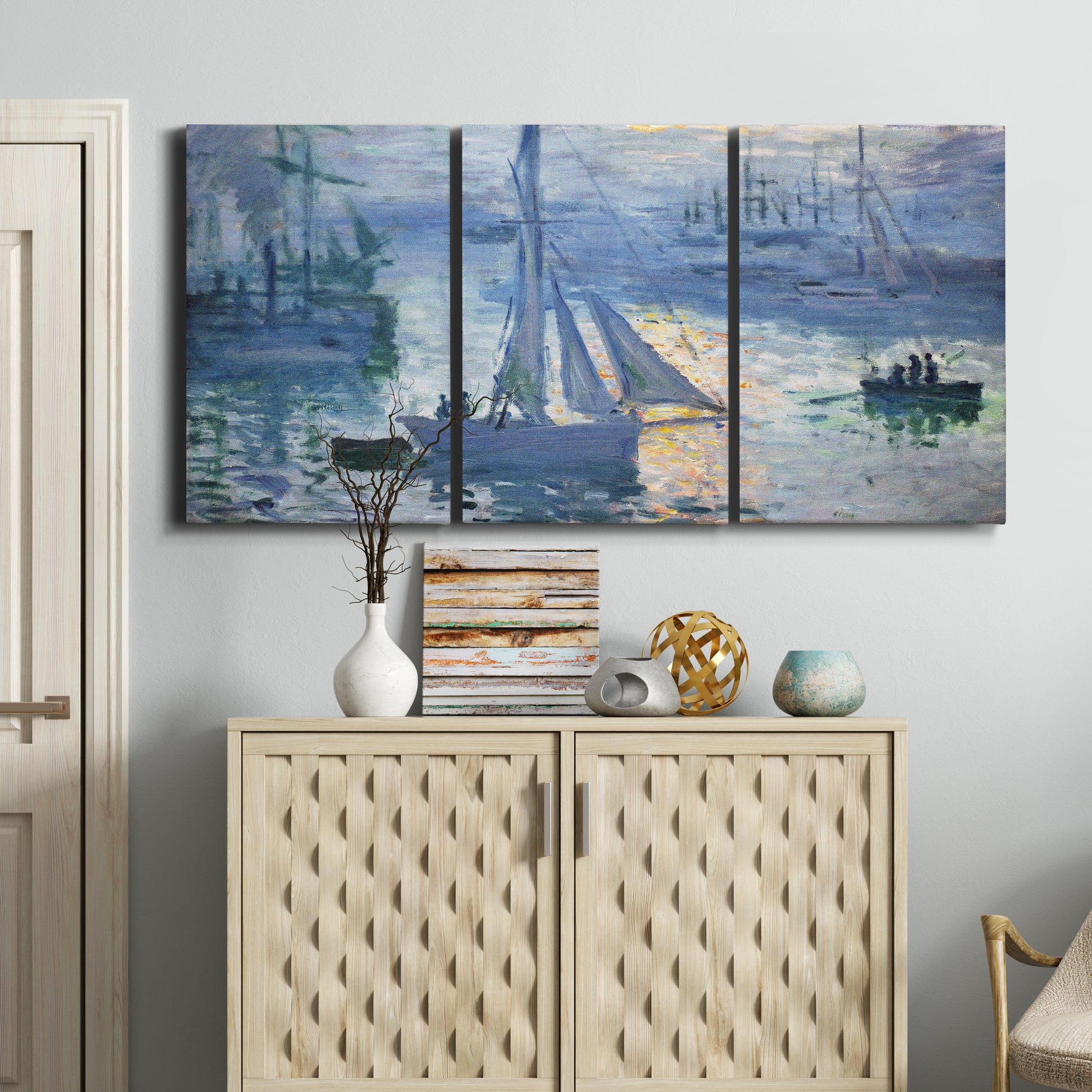 Three-panel canvas wall art featuring sailboats racing on river, displayed above a cabinet in an entryway.