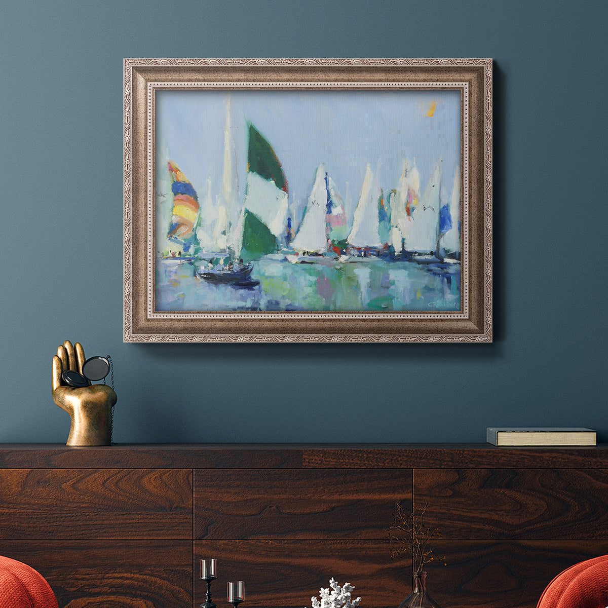 Coastal harbor watercolor painting in an ornate traditional silver frame displayed in a dark-toned interior setting.