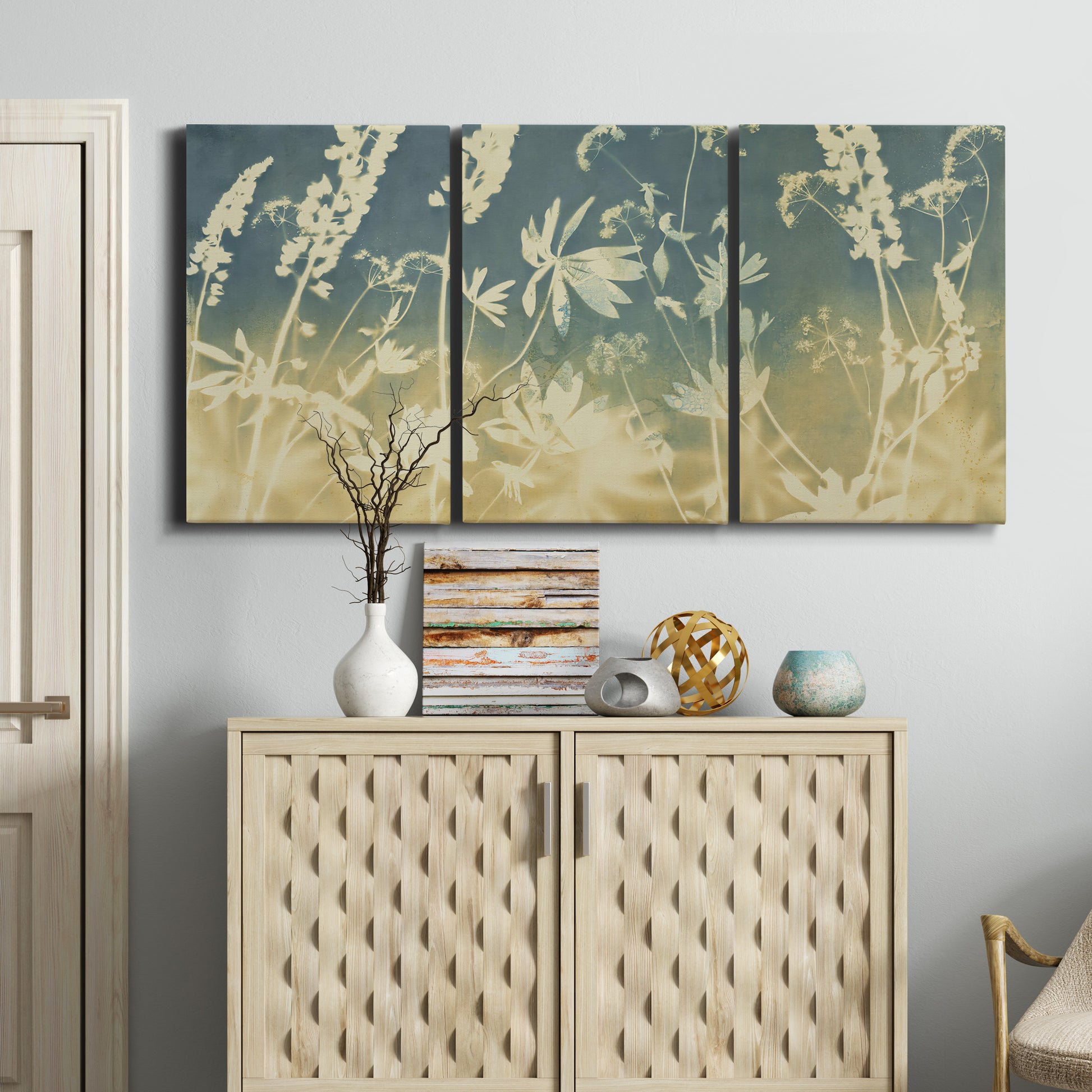 Three-panel canvas wall art featuring lupine flowers in seasonal bloom, displayed above a cabinet in an entryway.