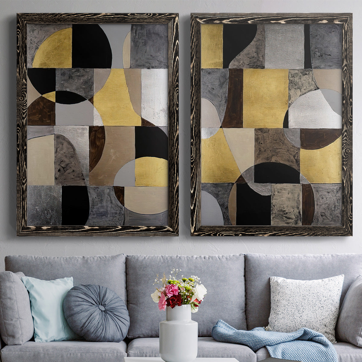 Set of two black barnwood framed canvas prints depicting paired structured modern abstracts with semicircles, rectangles, textured panels, and metallic-looking accents above a sofa in a contemporary living room.