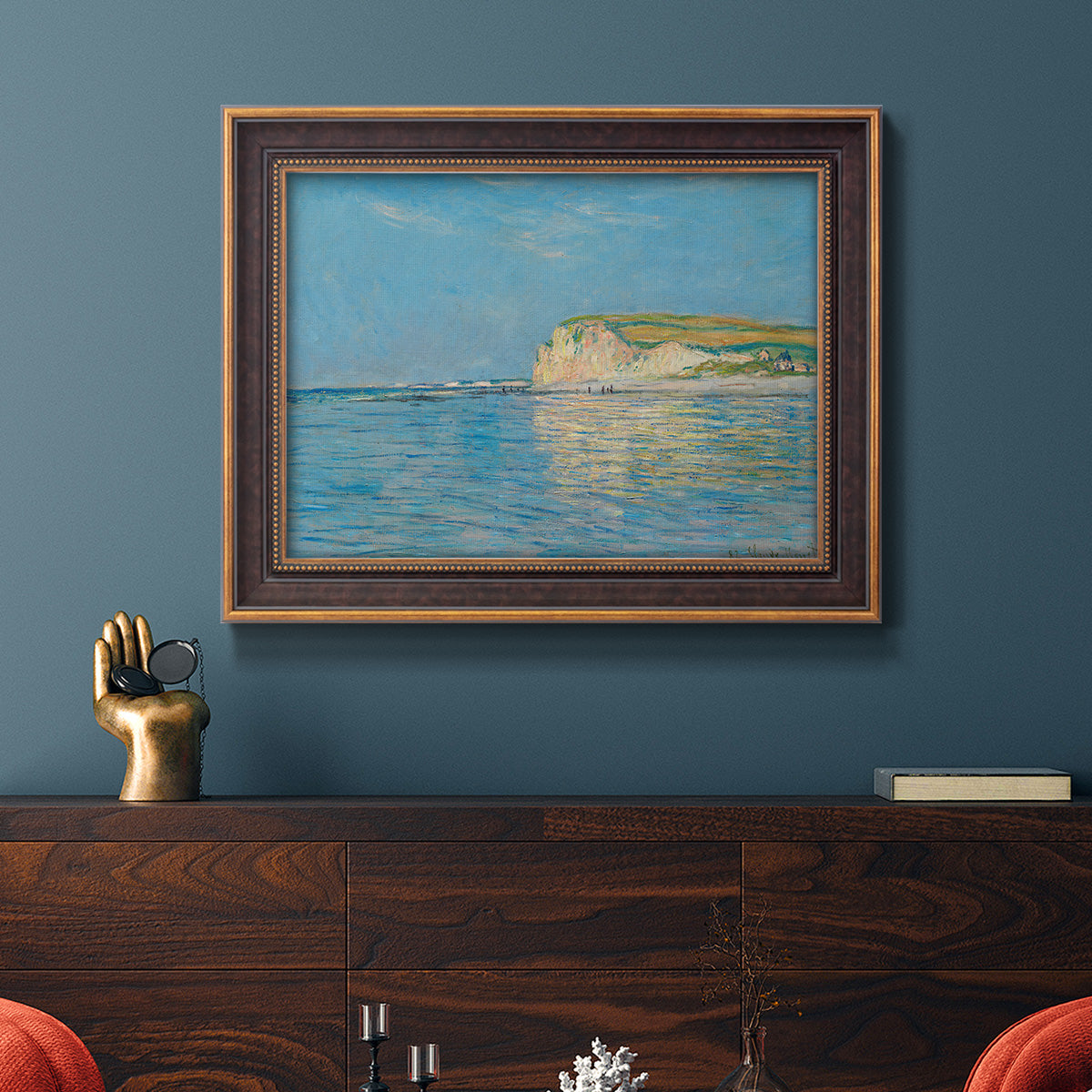Impressionist coastal low-tide seascape at Pourville by Claude Monet in an ornate bronzed mahogany wood frame displayed in a dark-toned interior setting.