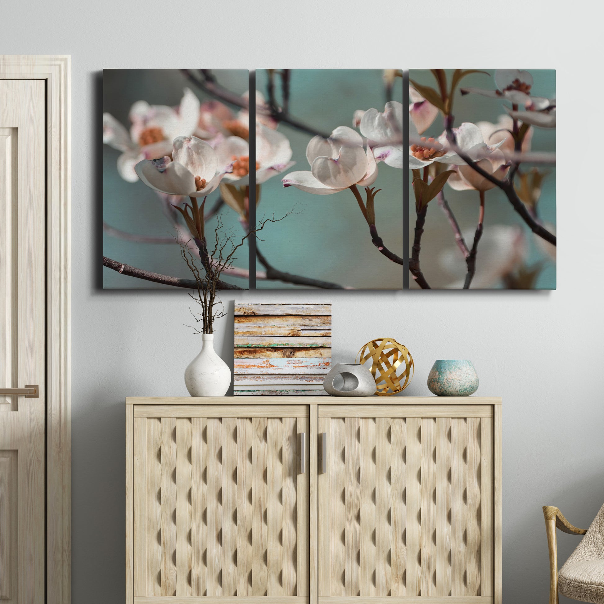 Three-panel canvas wall art featuring dogwood blossoms in spring photograph, displayed above a cabinet in an entryway.