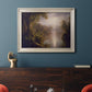 Luminous romantic landscape painting by Frederic Edwin Church in an ornate champagne frame displayed in a dark-toned interior setting.