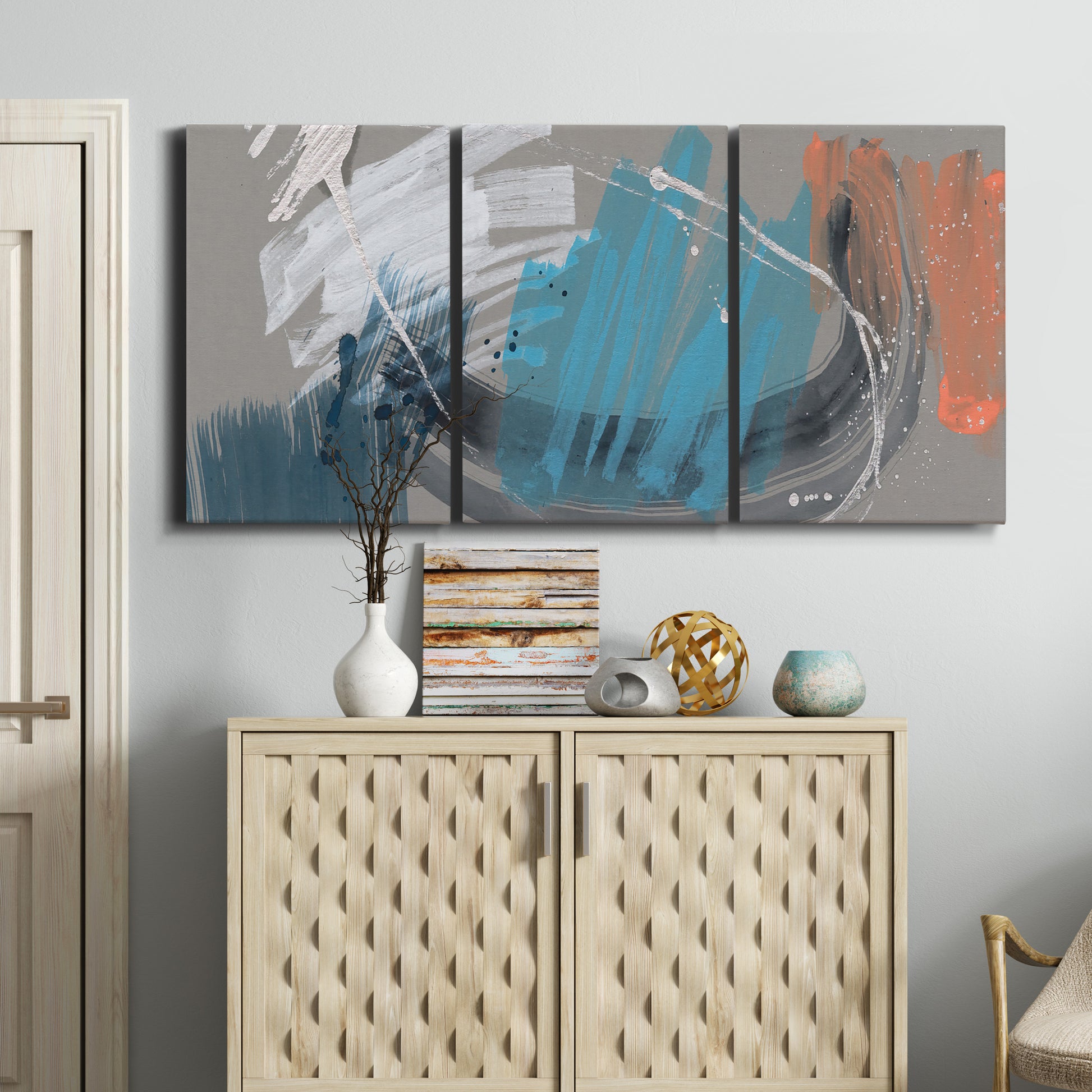 Three-panel canvas wall art featuring playful abstract mark making, displayed above a cabinet in an entryway.