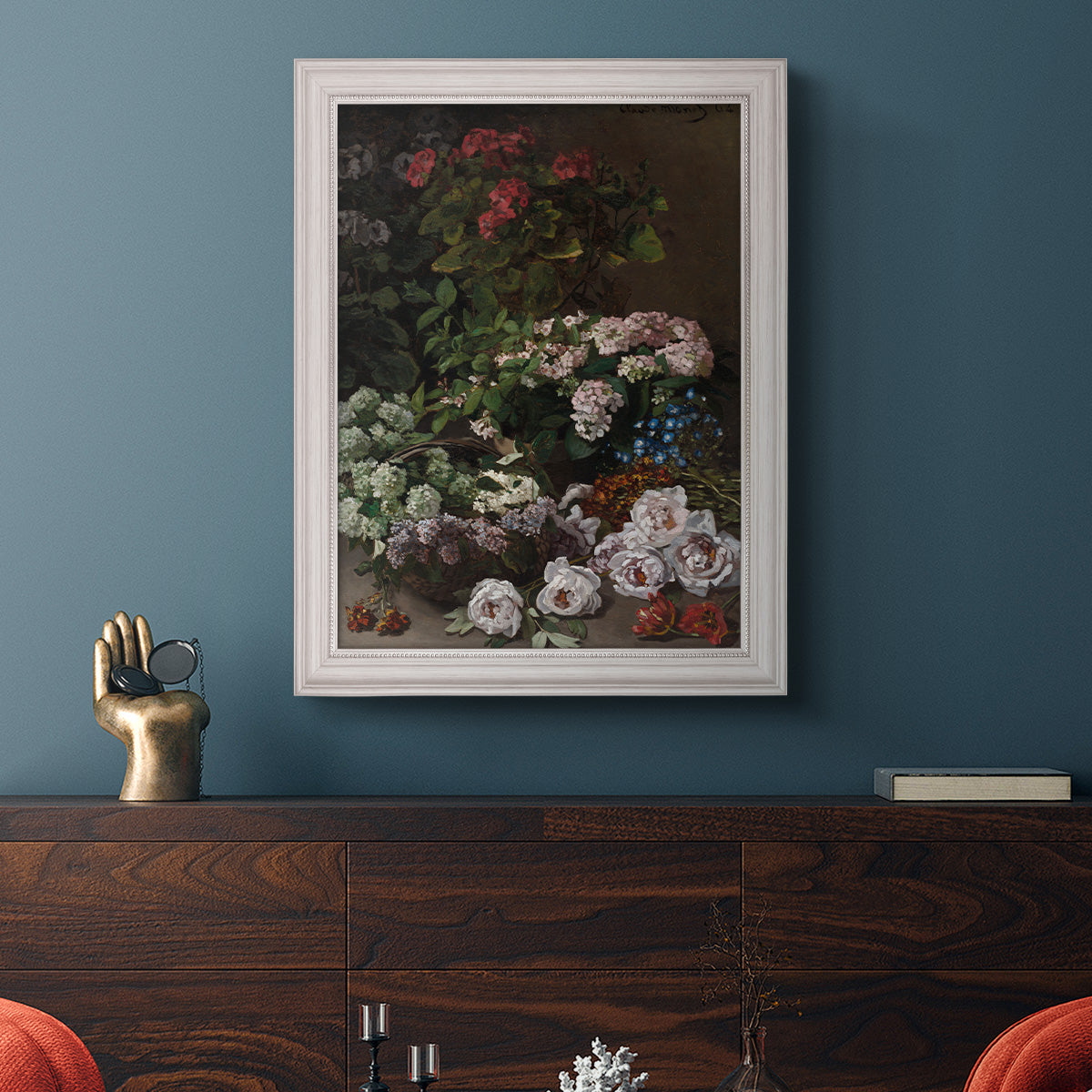 Early impressionist floral painting by Claude Monet in an ornate weathered white frame displayed in a dark-toned interior setting.