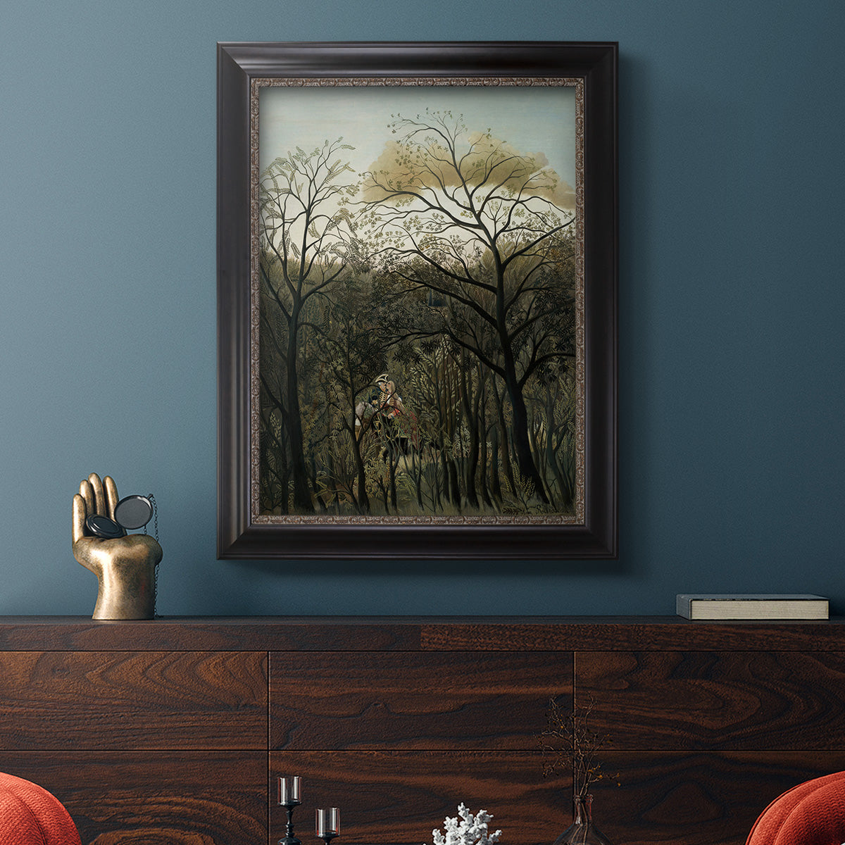Dreamlike forest landscape scene by Henri Rousseau in an ornate black frame with gilded inner detail displayed in a dark-toned interior setting.