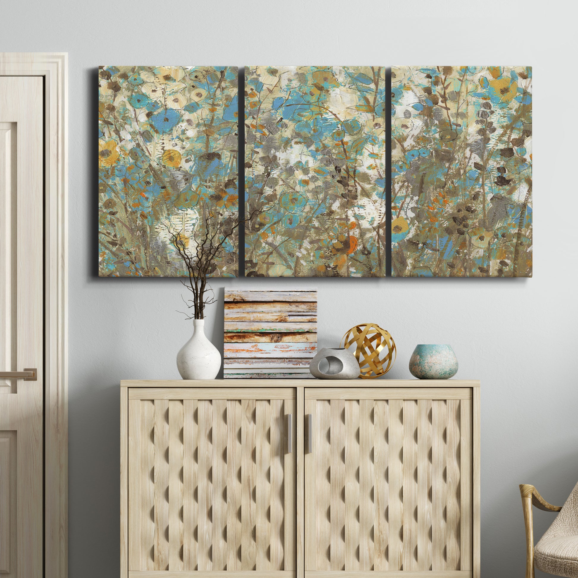 Three-panel canvas wall art featuring abstract flowering vine pattern, displayed above a cabinet in an entryway.