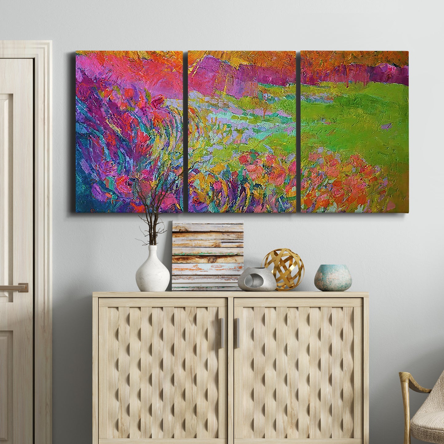 Three-panel canvas wall art featuring abstract meadow inspired color fields, displayed above a cabinet in an entryway.