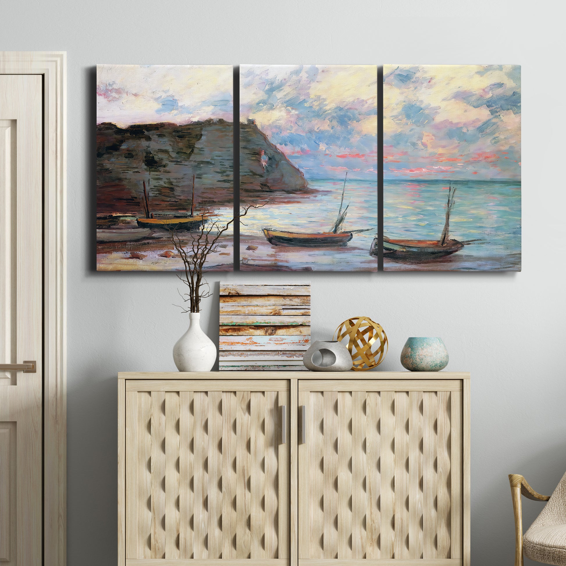 Three-panel canvas wall art featuring golden coastal sunset with cliffs, displayed above a cabinet in an entryway.