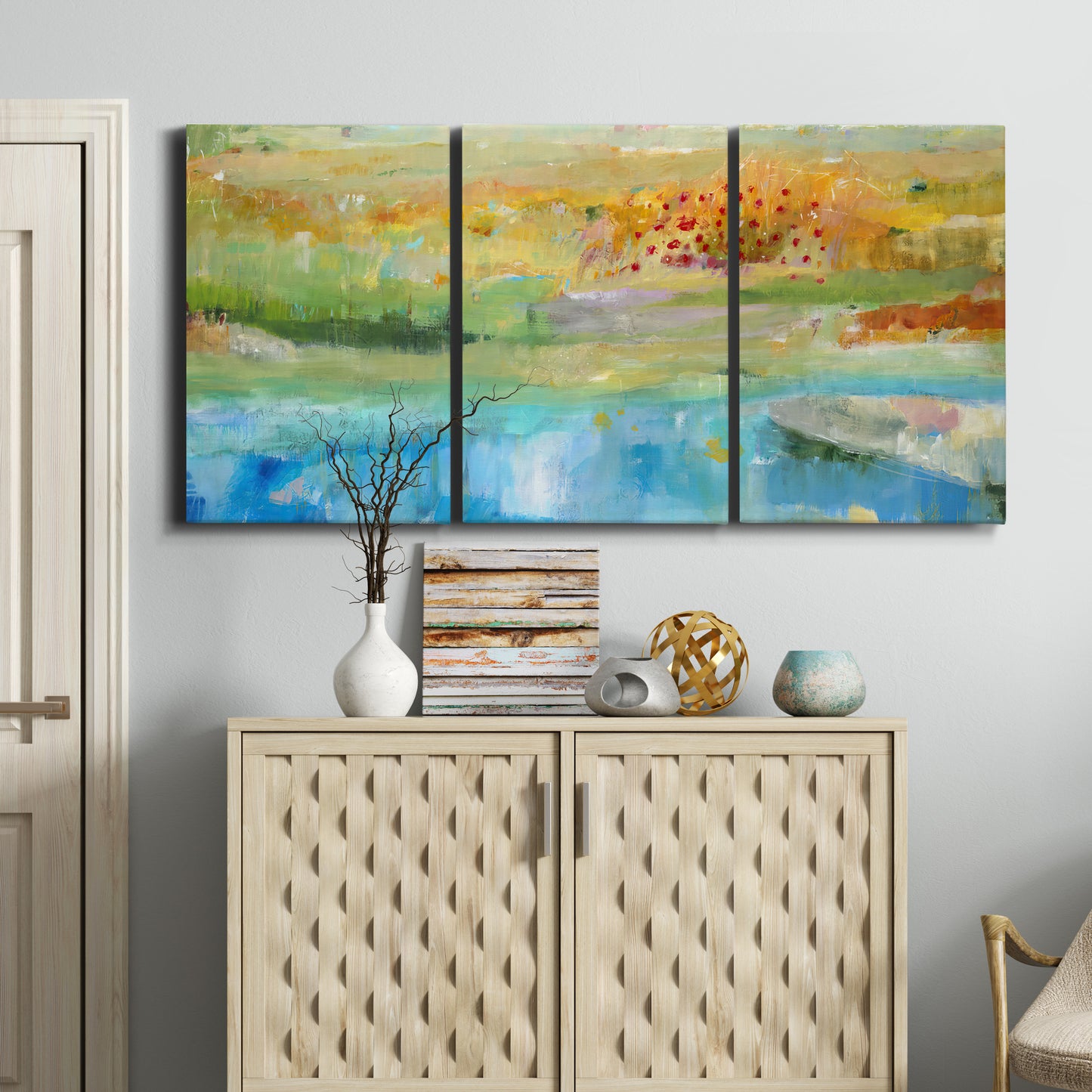 Three-panel canvas wall art featuring abstract sense of forward movement, displayed above a cabinet in an entryway.