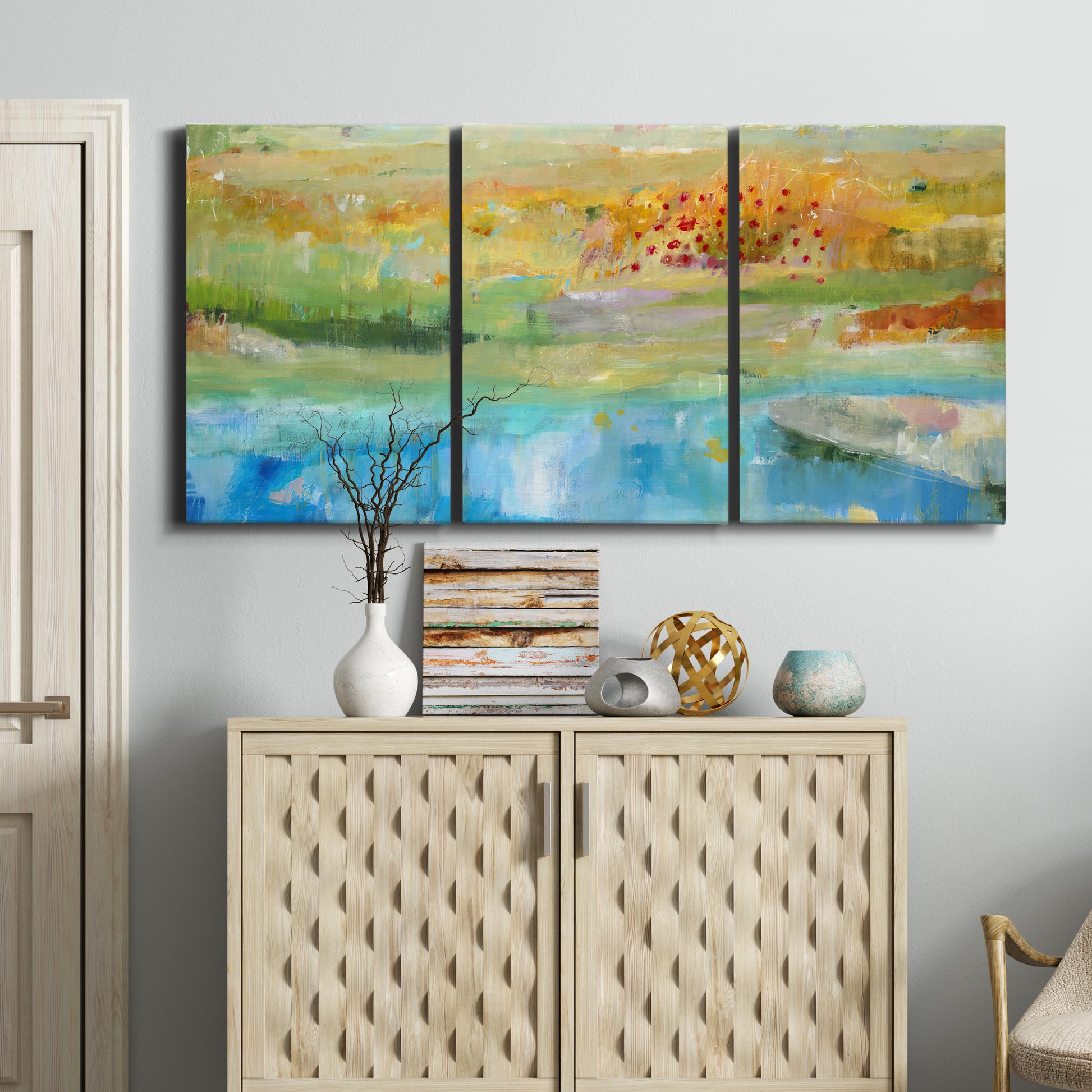 Three-panel canvas wall art featuring abstract sense of forward movement, displayed above a cabinet in an entryway.