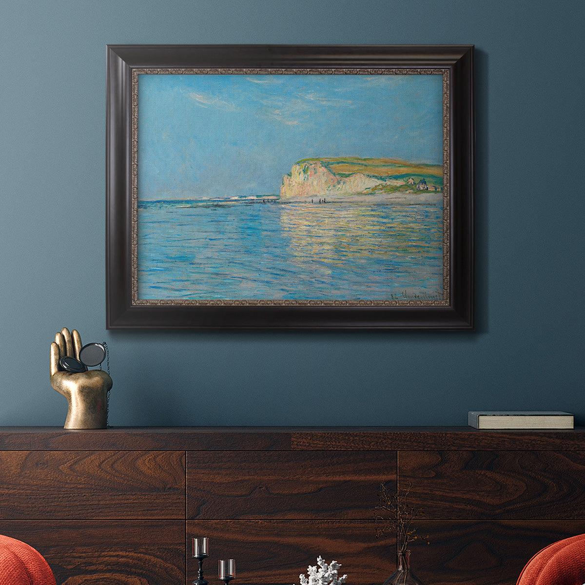 Impressionist coastal low-tide seascape at Pourville by Claude Monet in an ornate black frame with gilded inner detail displayed in a dark-toned interior setting.