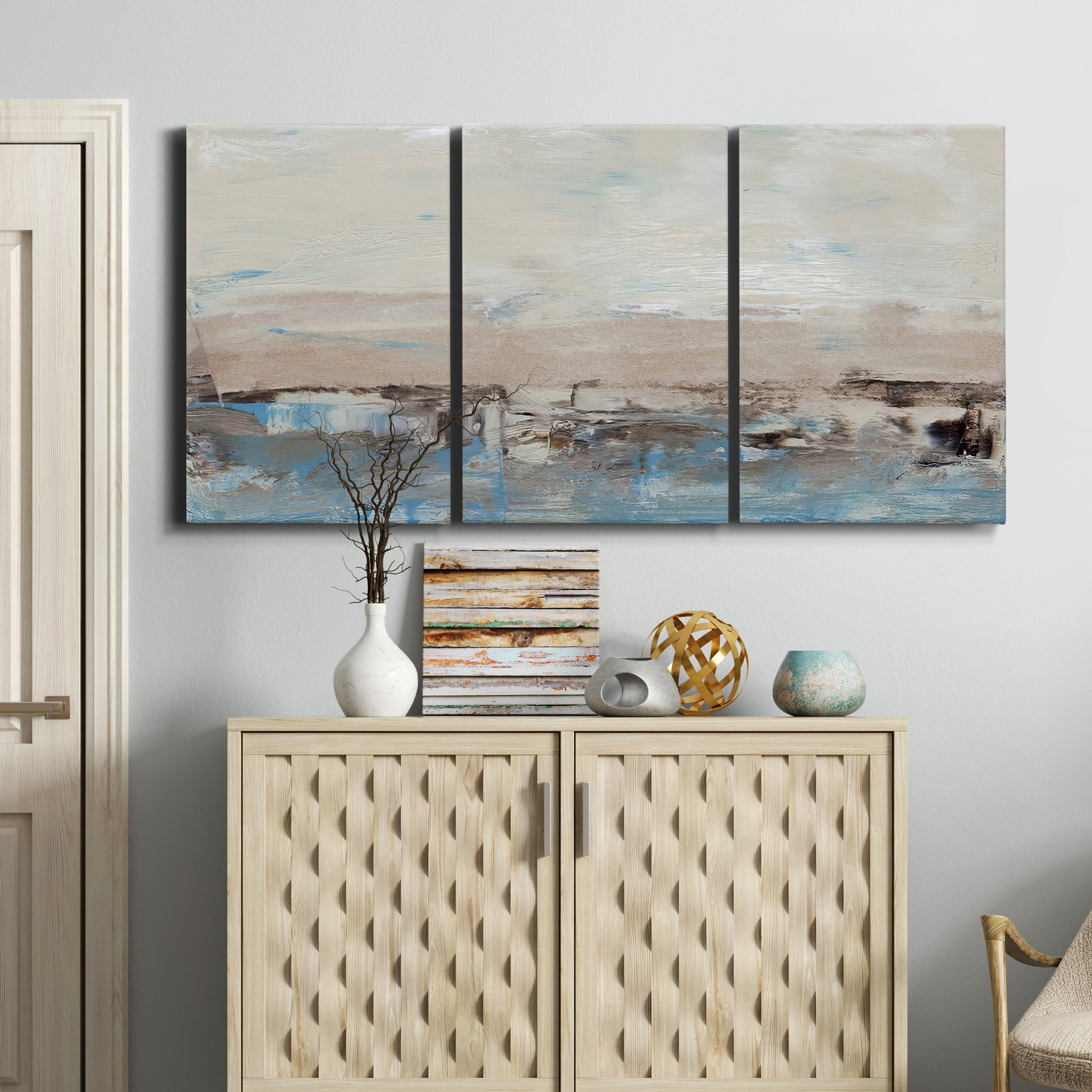 Three-panel canvas wall art featuring abstract bridge landscape in cyan, displayed above a cabinet in an entryway.