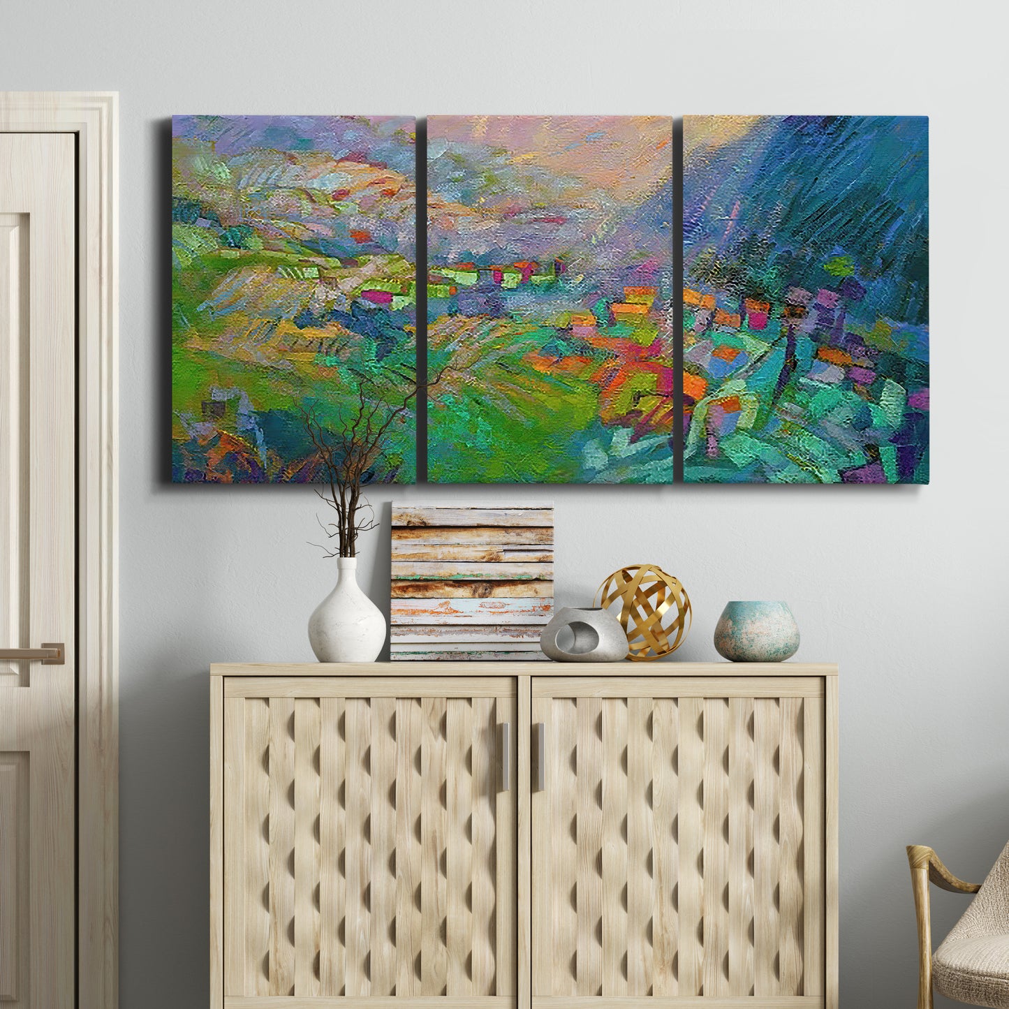 Three-panel canvas wall art featuring embracing landscape with warm tones, displayed above a cabinet in an entryway.