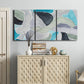 Three-panel canvas wall art featuring subtle abstract billowing color layers, displayed above a cabinet in an entryway.
