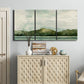 Three-panel canvas wall art featuring riverbank watercolor landscape, displayed above a cabinet in an entryway.
