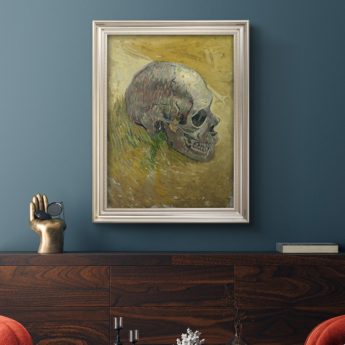 Profile skull study artwork by Vincent van Gogh in an ornate champagne frame displayed in a dark-toned interior setting.