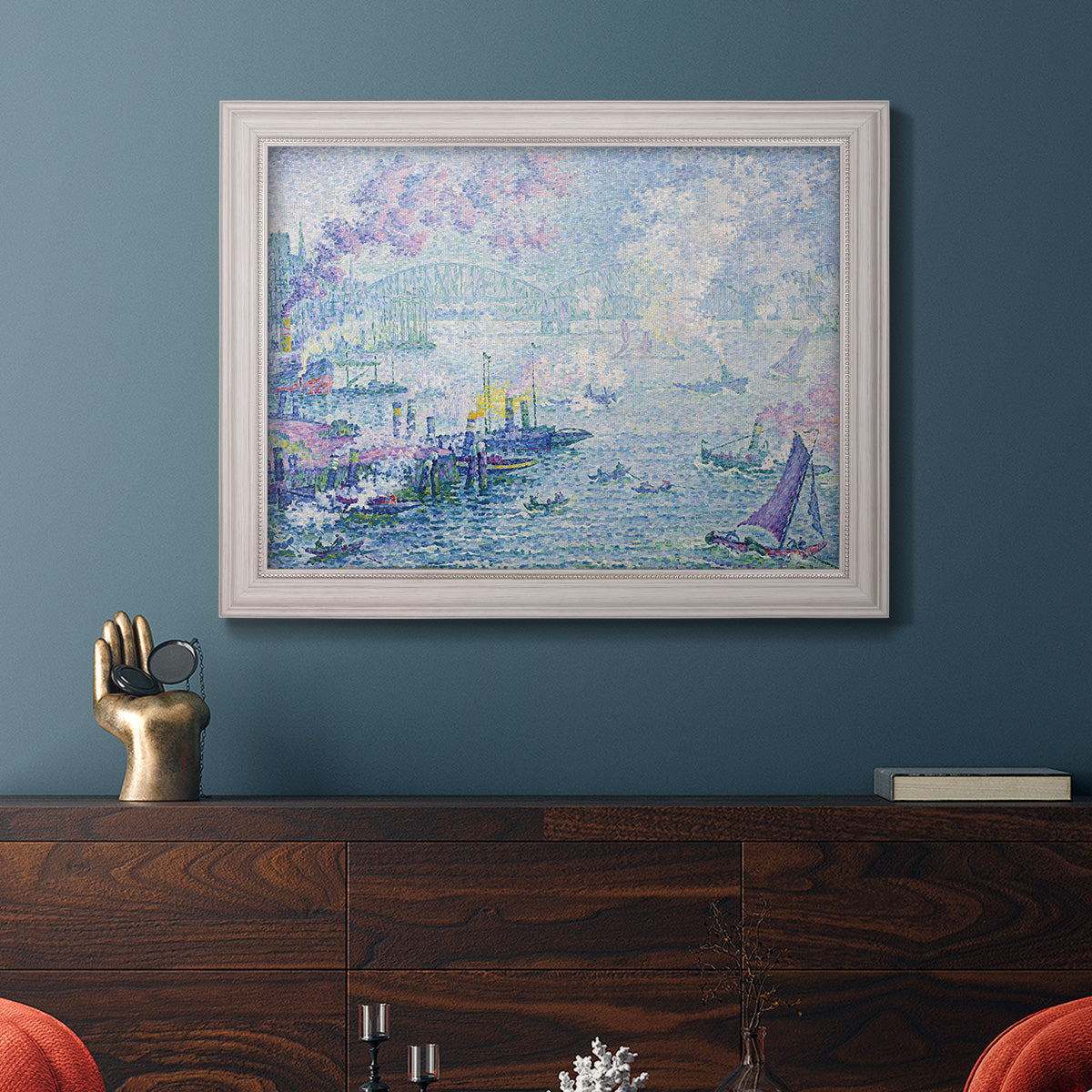 Impressionist industrial harbor scene by Paul Signac in an ornate weathered white frame displayed in a dark-toned interior setting.