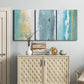 Three-panel canvas wall art featuring abstract coastal shoreline textures, displayed above a cabinet in an entryway.