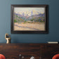 Impressionist valley landscape in southern France by Claude Monet in an ornate black frame with gilded inner detail displayed in a dark-toned interior setting.