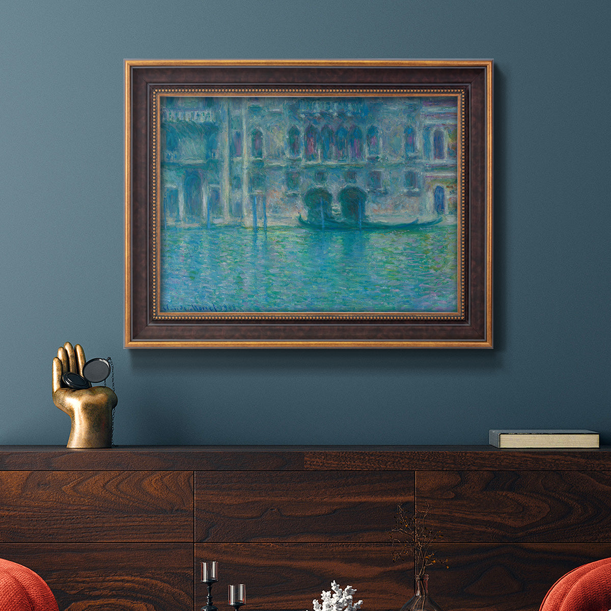 Impressionist Venetian palace waterfront scene by Claude Monet in an ornate bronzed mahogany wood frame displayed in a dark-toned interior setting.