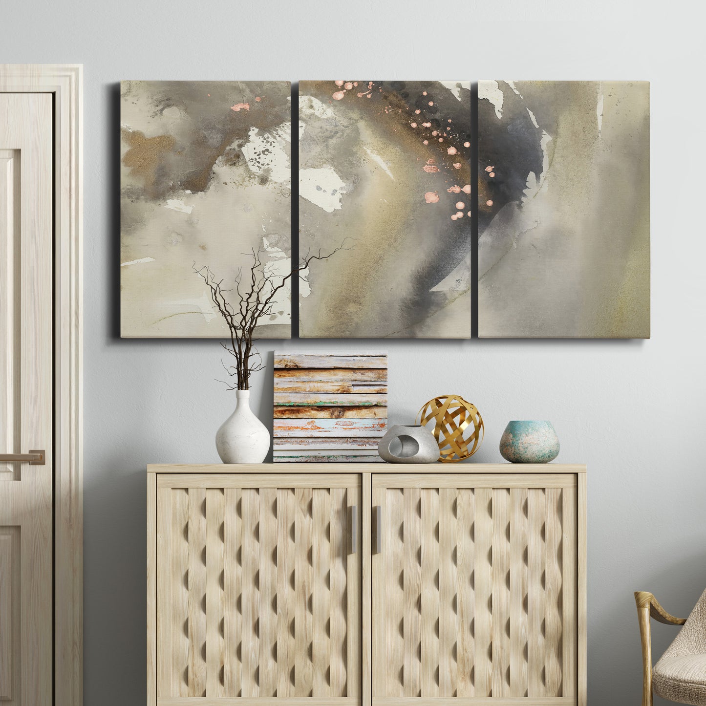 Three-panel canvas wall art featuring flowing abstract wave motion, displayed above a cabinet in an entryway.