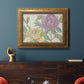 Contemporary peony flower illustration in an ornate vintage gold frame displayed in a dark-toned interior setting.