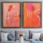 Set of two walnut barnwood framed canvas prints depicting paired glamorous fluid abstracts with translucent warm washes, drips, and scattered metallic accents above a sofa in a contemporary living room.