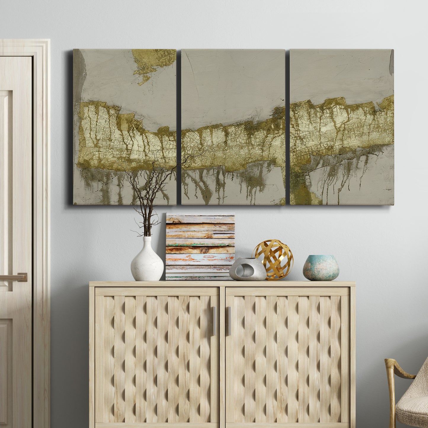 Three-panel canvas wall art featuring gold accented abstract ravine, displayed above a cabinet in an entryway.