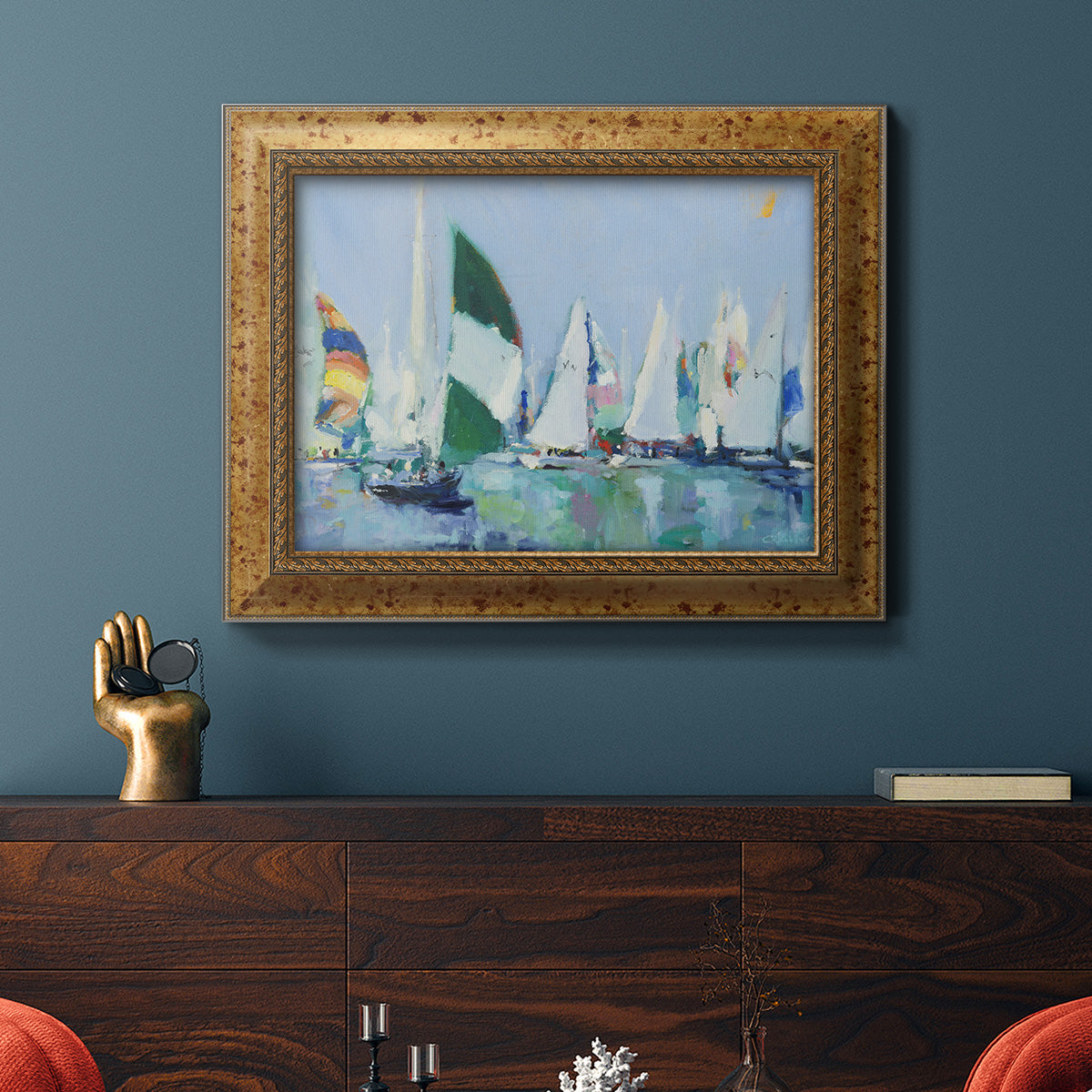 Coastal harbor watercolor painting in an ornate vintage gold frame displayed in a dark-toned interior setting.