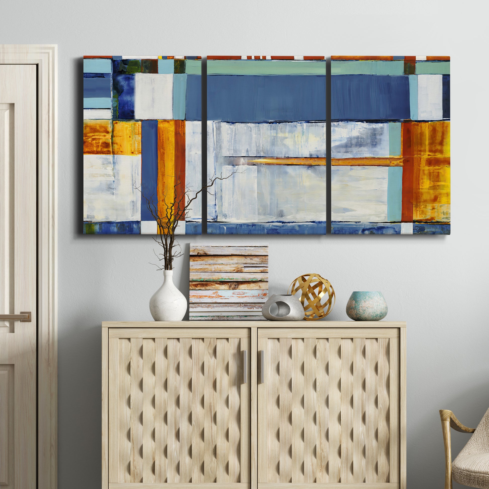 Three-panel canvas wall art featuring bright mid century geometric abstraction, displayed above a cabinet in an entryway.