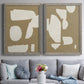 Set of two gray barnwood framed canvas prints depicting paired bold minimalist shape abstracts with flat blocky forms, rough painted edges, and strong negative space above a sofa in a contemporary living room.