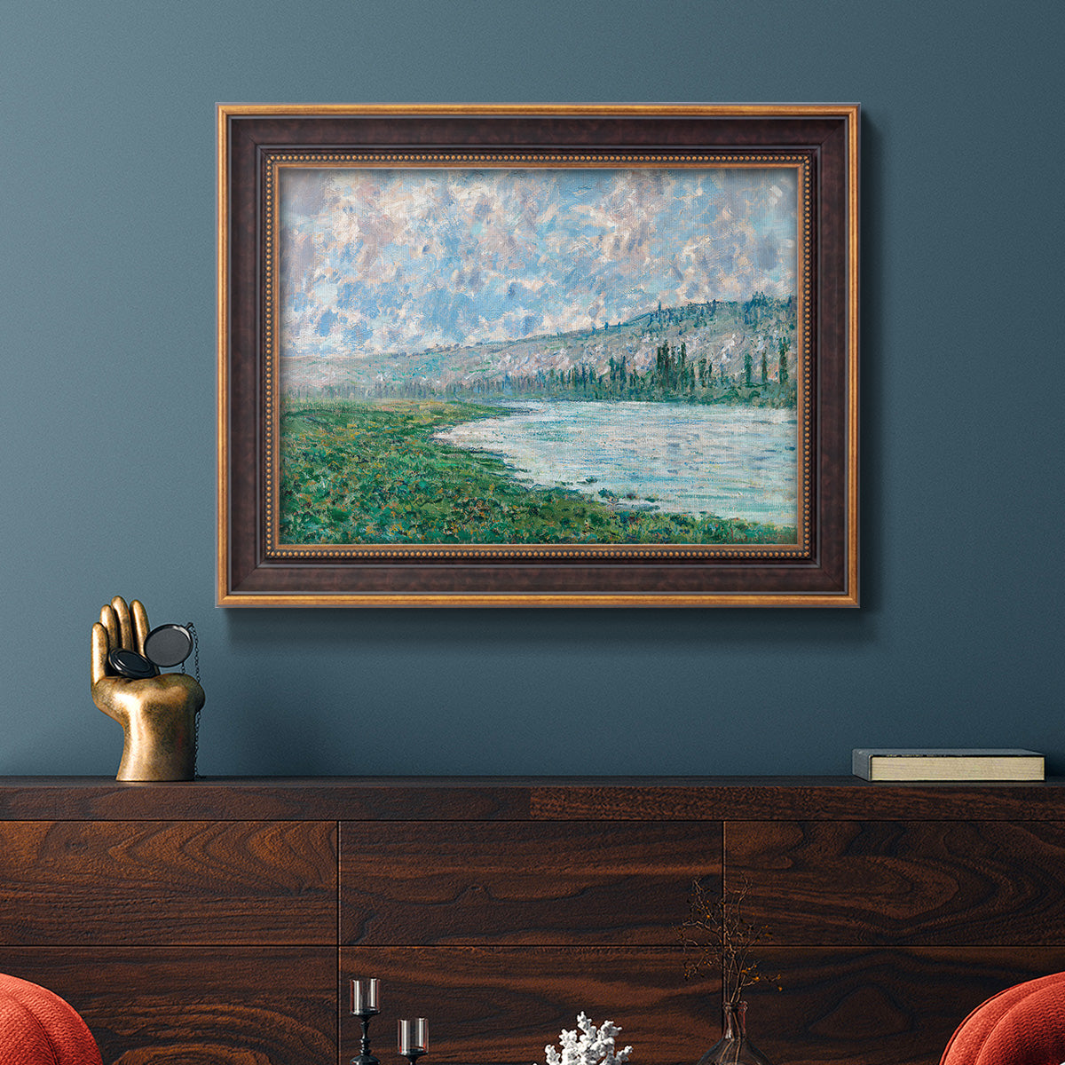 Impressionist river landscape at Vétheuil by Claude Monet in an ornate bronzed mahogany wood frame displayed in a dark-toned interior setting.