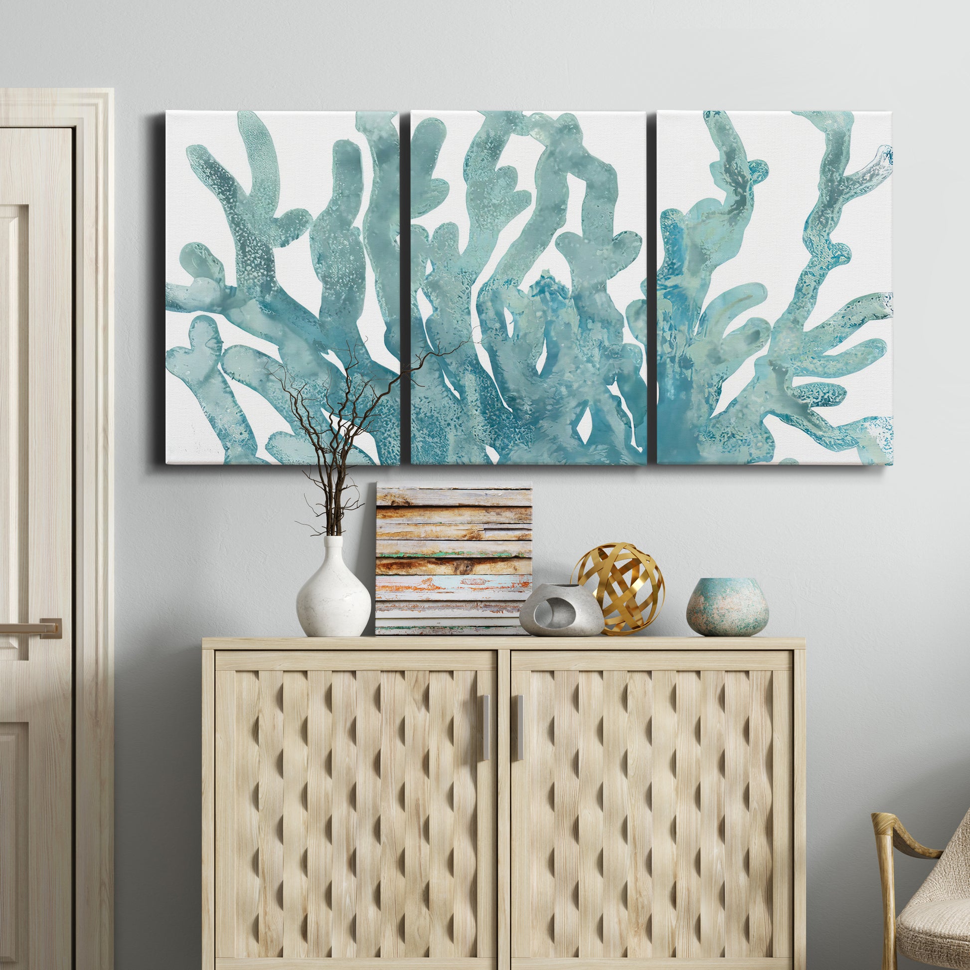 Three-panel canvas wall art featuring blue coral inspired watercolor, displayed above a cabinet in an entryway.
