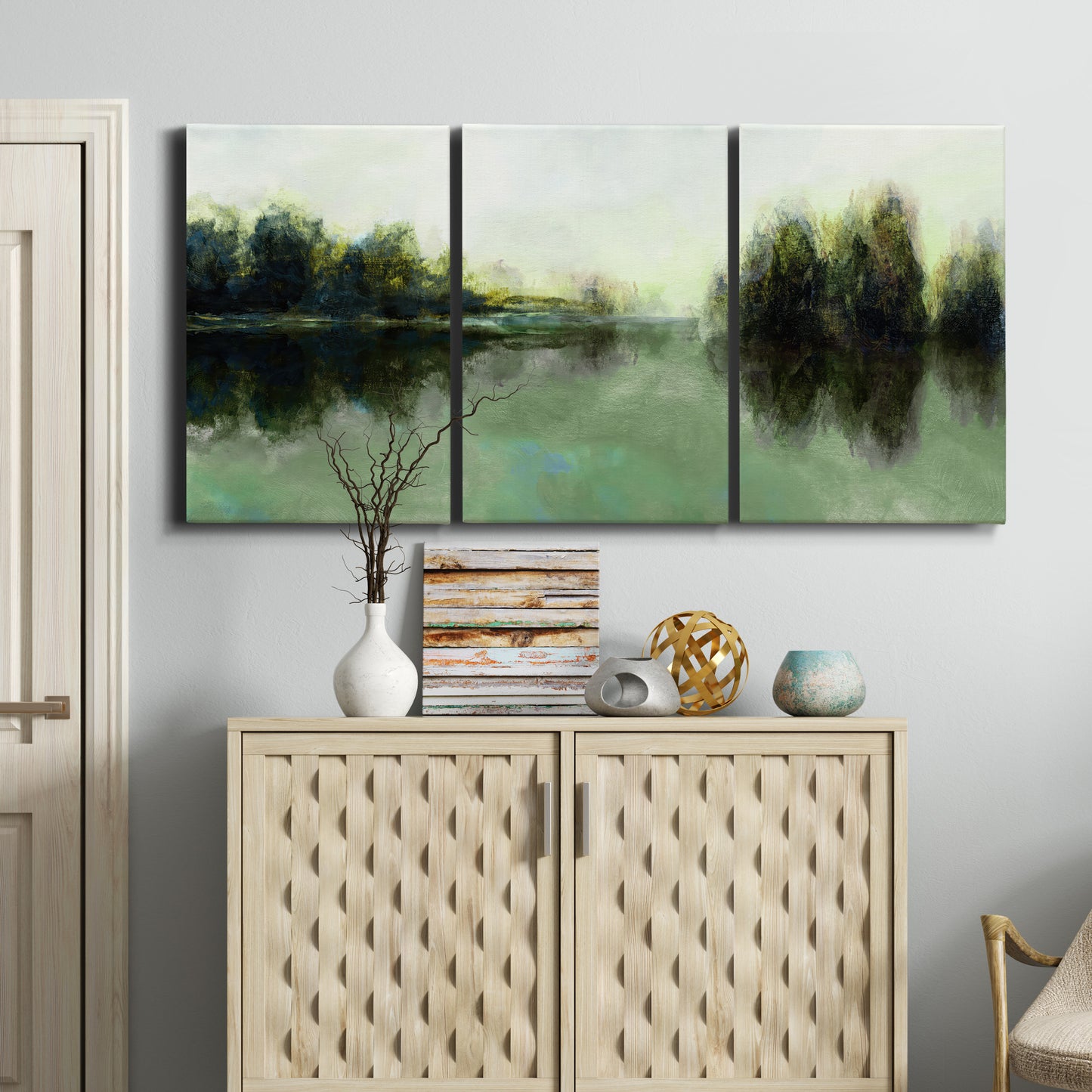 Three-panel canvas wall art featuring rain soaked landscape at sunset, displayed above a cabinet in an entryway.