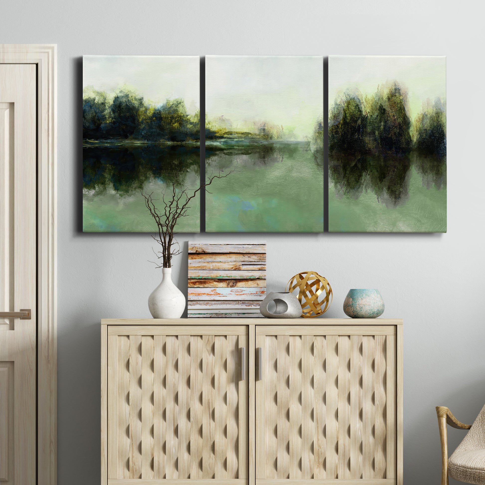Three-panel canvas wall art featuring rain soaked landscape at sunset, displayed above a cabinet in an entryway.