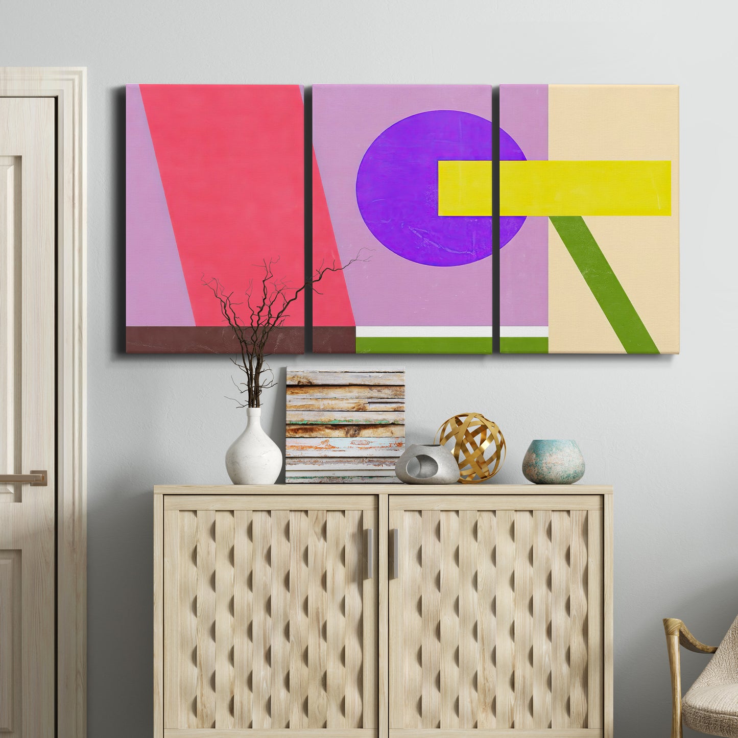 Three-panel canvas wall art featuring bold geometric color abstraction, displayed above a cabinet in an entryway.