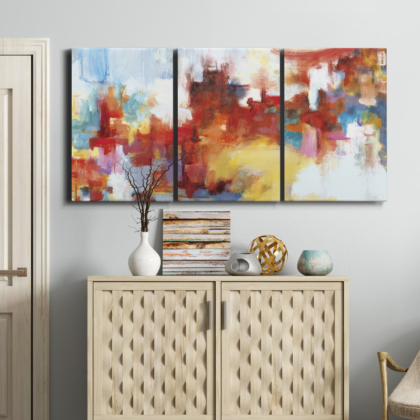 Three-panel canvas wall art featuring abstract city lights composition, displayed above a cabinet in an entryway.