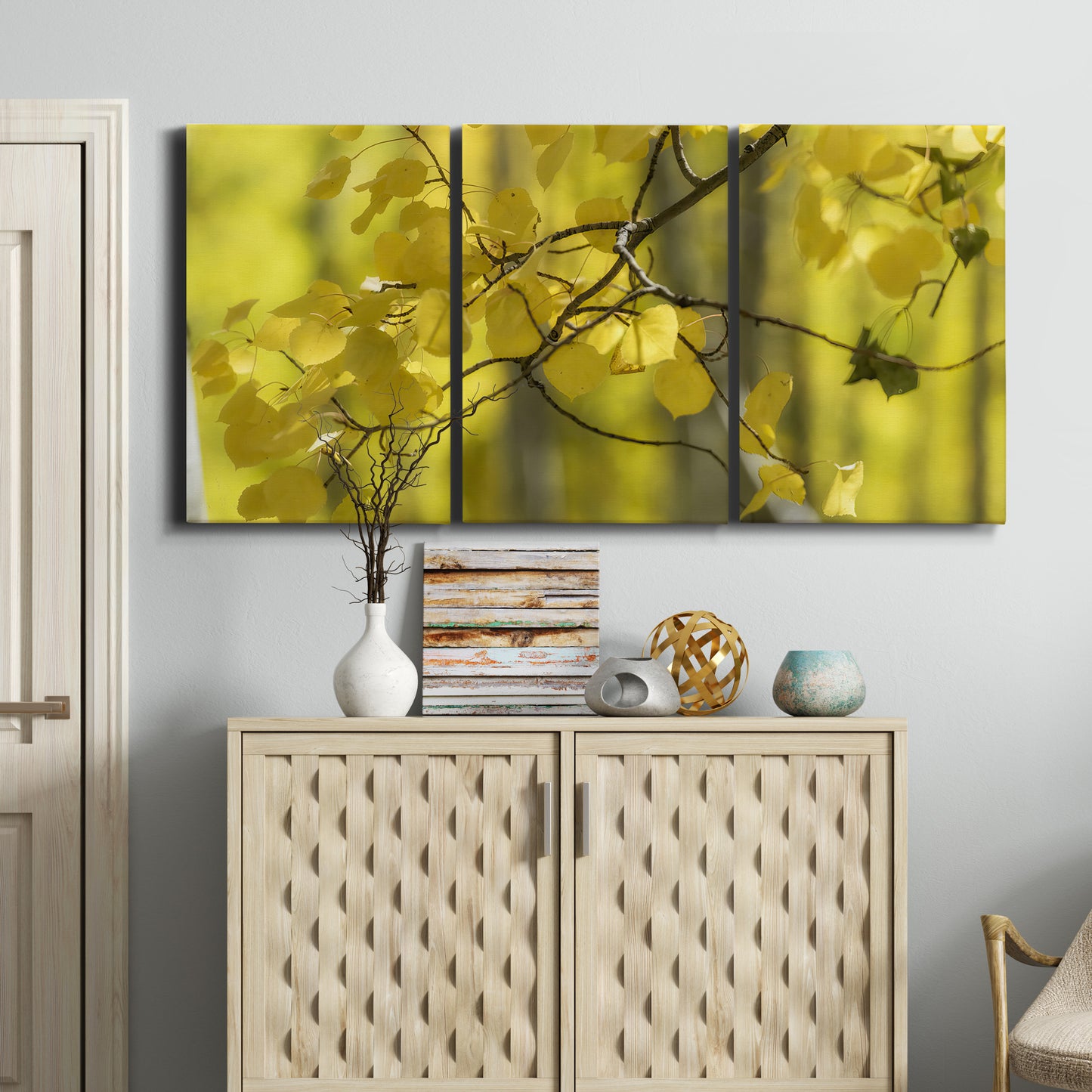 Three-panel canvas wall art featuring backlit aspen trees photograph, displayed above a cabinet in an entryway.