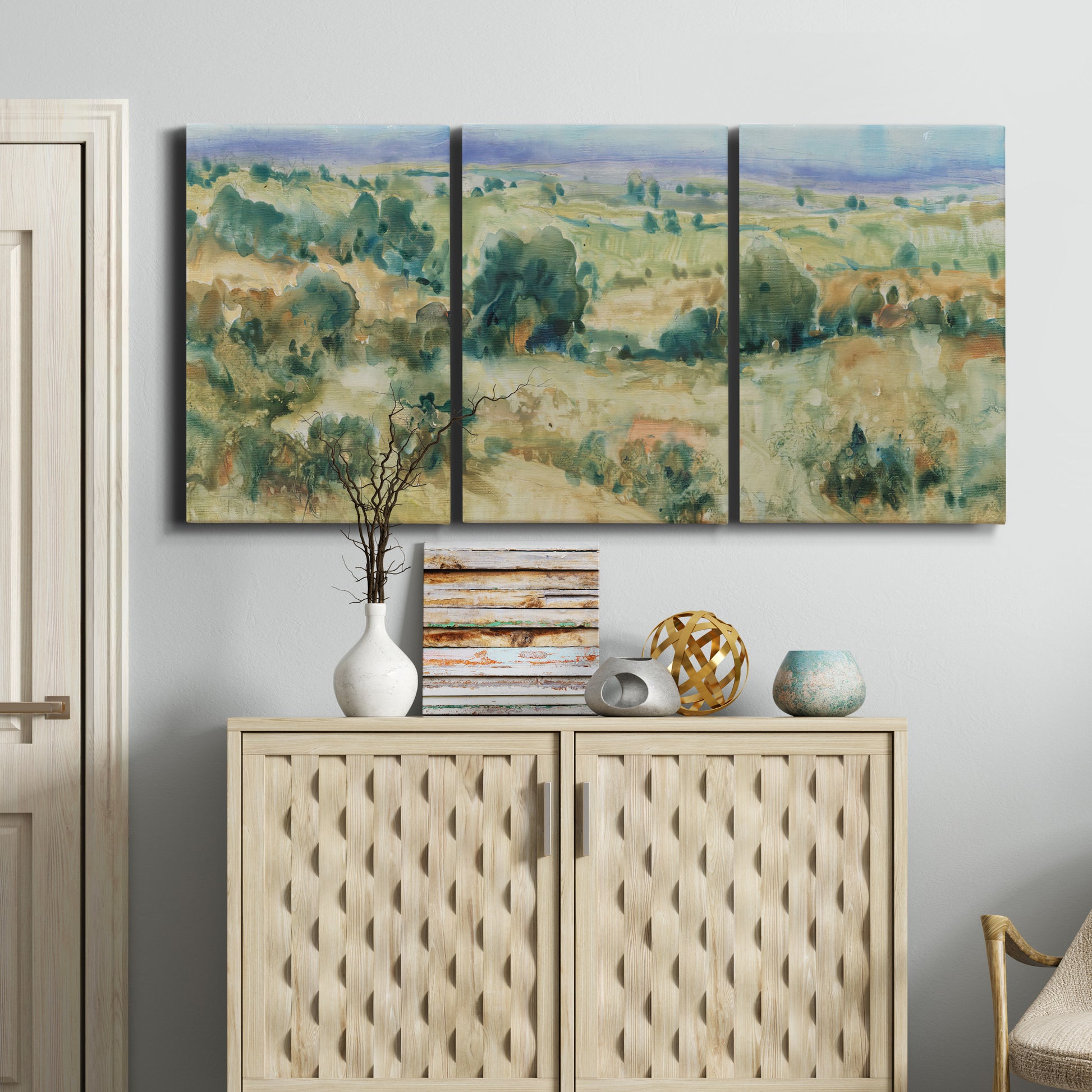 Three-panel canvas wall art featuring lavender sky over quiet landscape, displayed above a cabinet in an entryway.