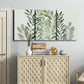 Three-panel canvas wall art featuring foraged leafy greens botanical study, displayed above a cabinet in an entryway.