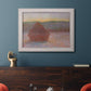 Impressionist haystack sunset scene in winter by Claude Monet in an ornate weathered white frame displayed in a dark-toned interior setting.