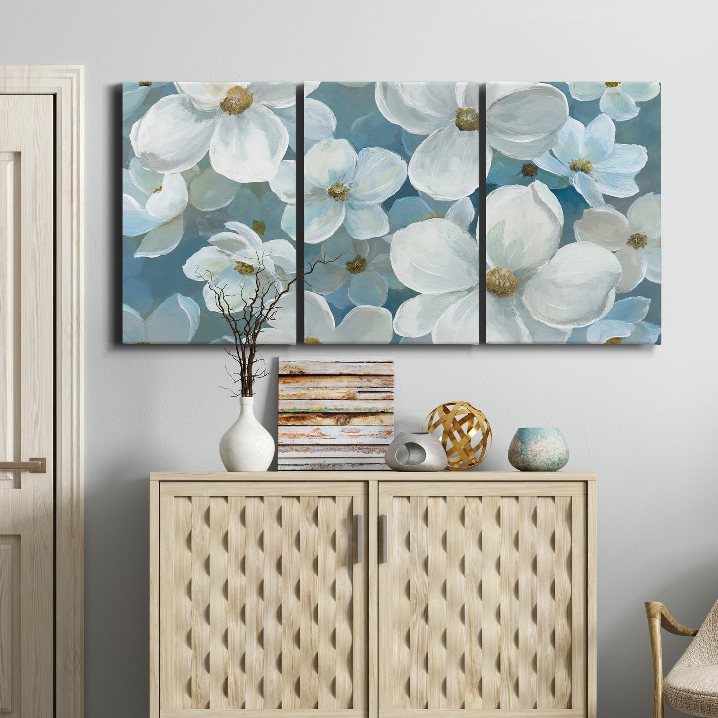 Three-panel canvas wall art featuring soft white floral abstraction, displayed above a cabinet in an entryway.