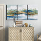 Three-panel canvas wall art featuring abstract blue watercolor landscape, displayed above a cabinet in an entryway.