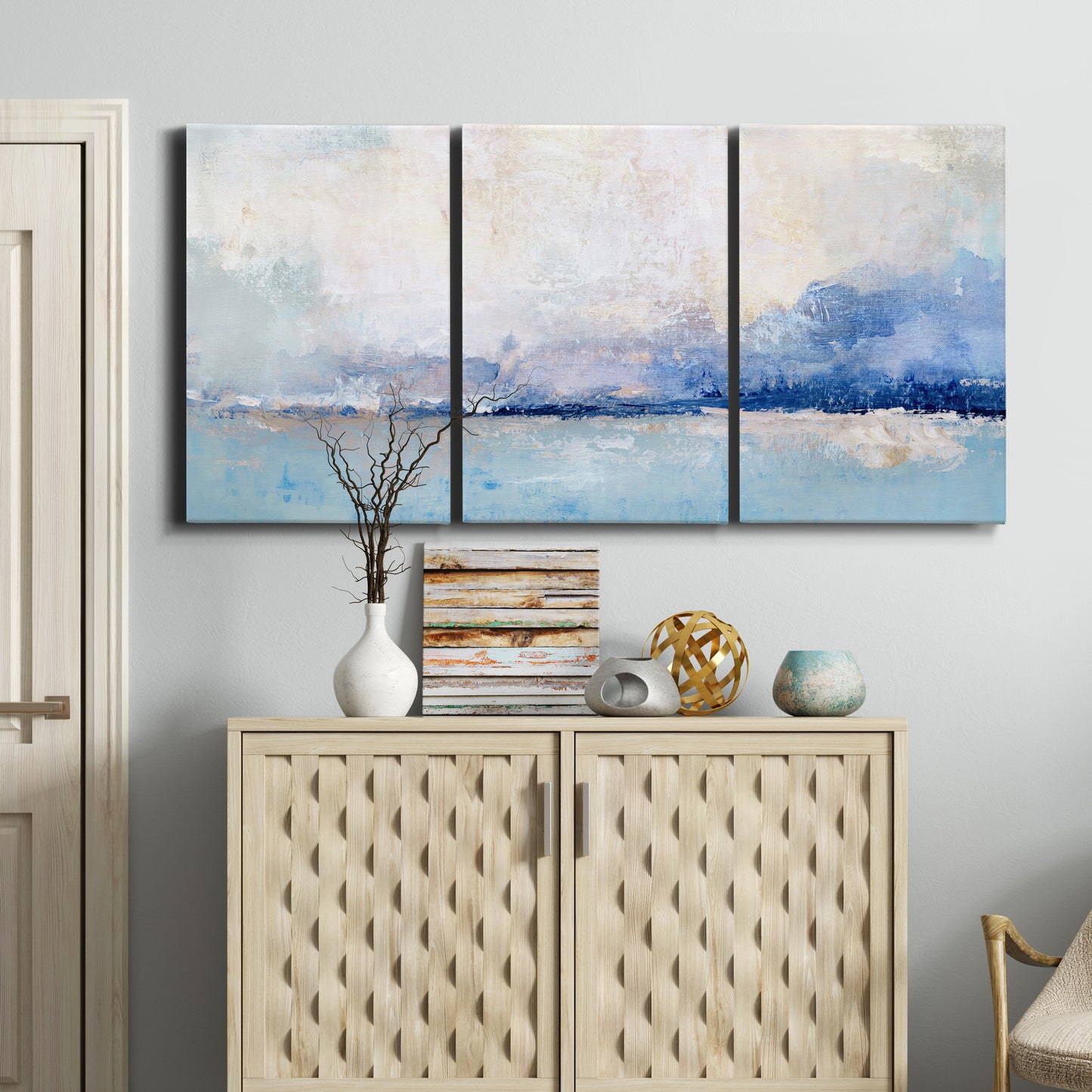 Three-panel canvas wall art featuring abstract bay with rhythmic forms, displayed above a cabinet in an entryway.