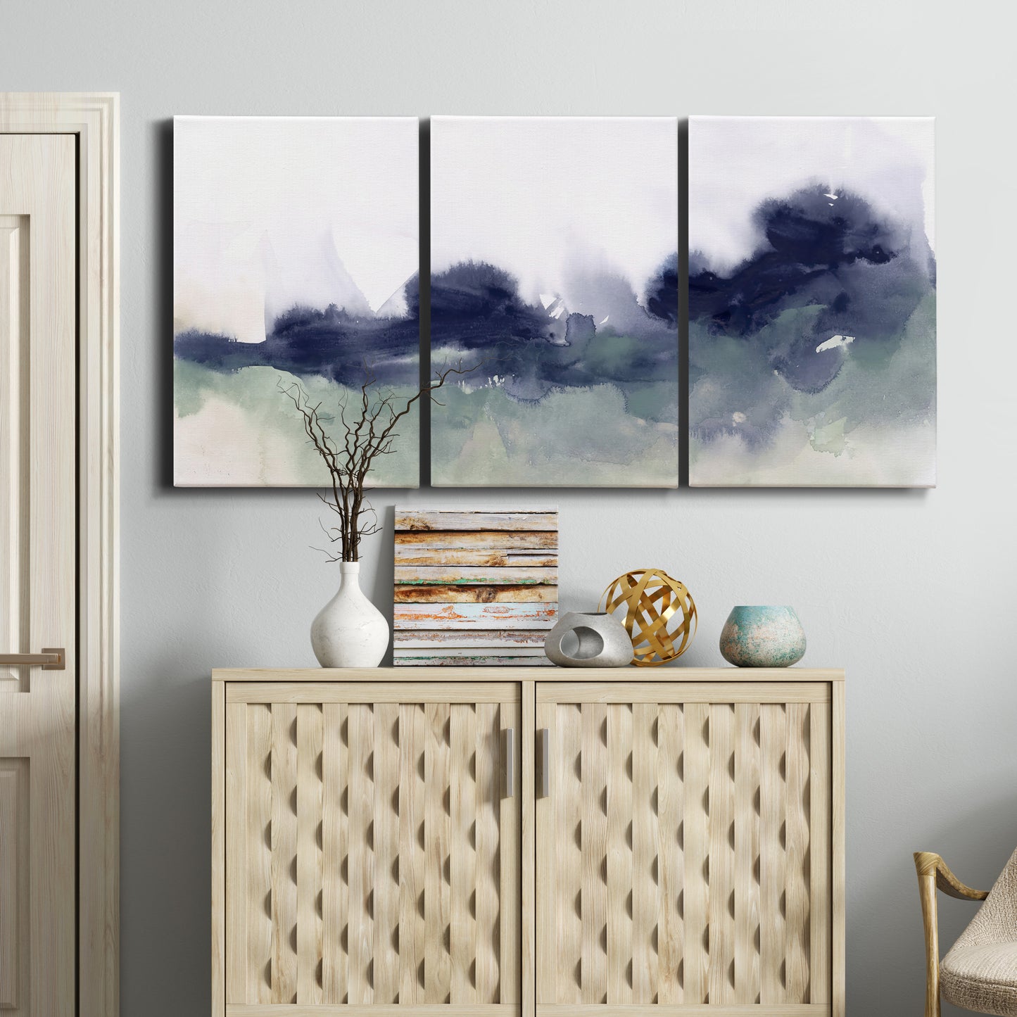 Three-panel canvas wall art featuring misty abstract lake watercolor, displayed above a cabinet in an entryway.