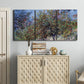 Three-panel canvas wall art featuring orchard of trees in spring bloom, displayed above a cabinet in an entryway.