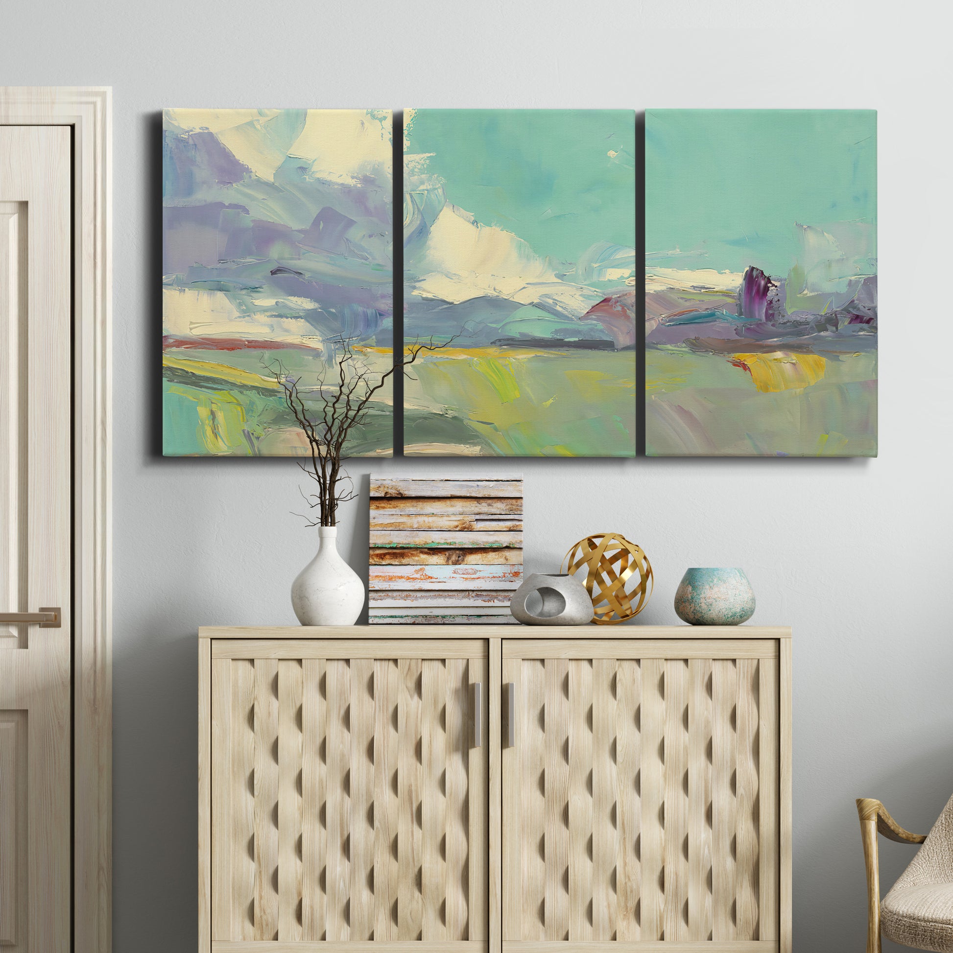 Three-panel canvas wall art featuring road stretching through open countryside, displayed above a cabinet in an entryway.