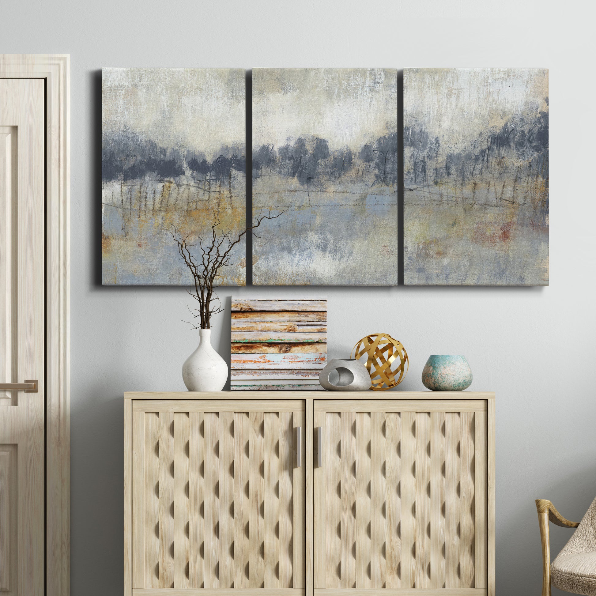 Three-panel canvas wall art featuring soft grey abstract horizon, displayed above a cabinet in an entryway.