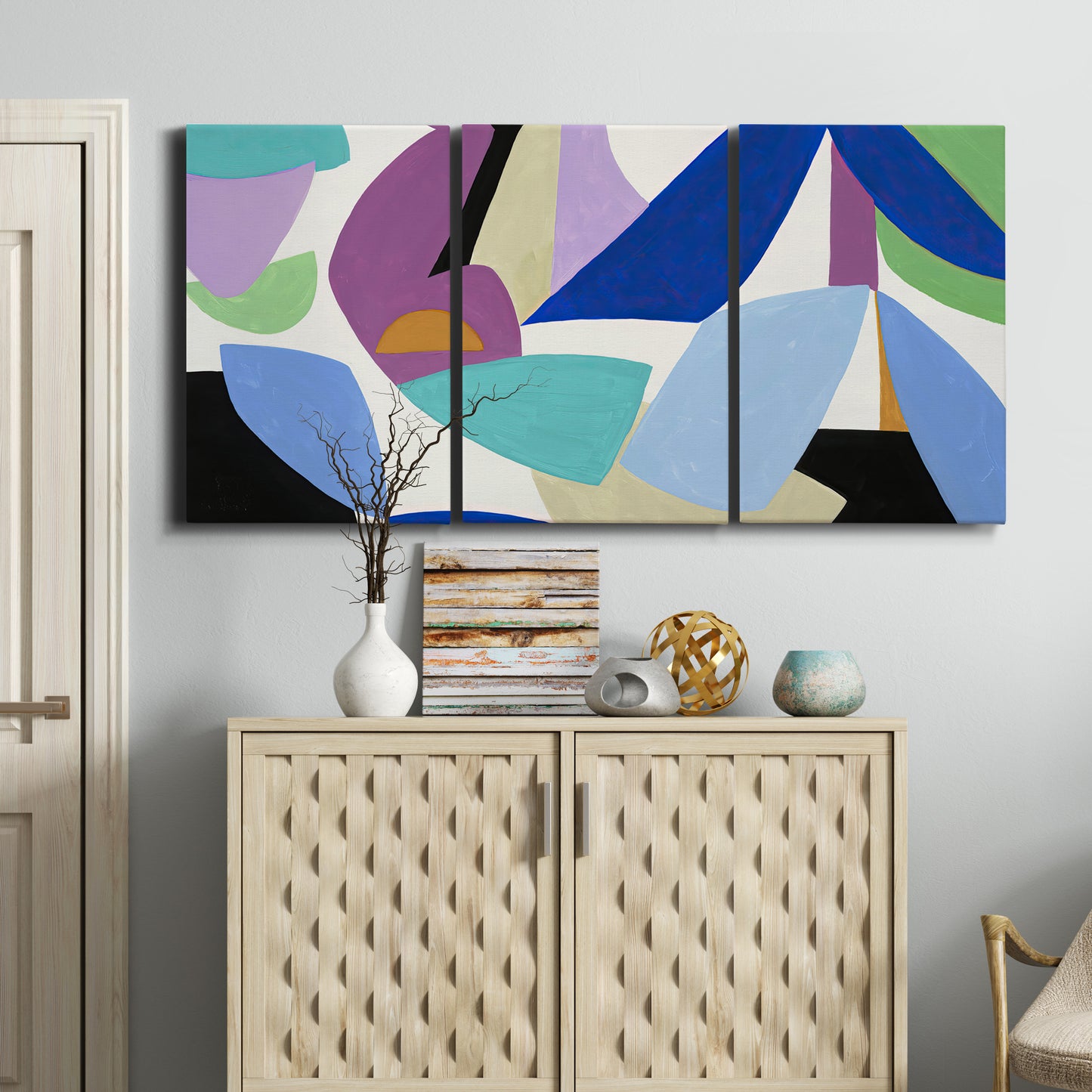 Three-panel canvas wall art featuring colorful abstract homage to modernism, displayed above a cabinet in an entryway.